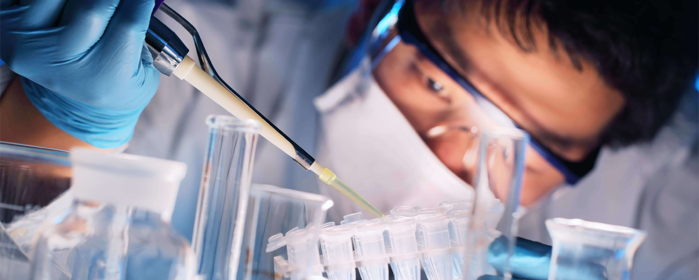 A scientist placing a solution into test tubes