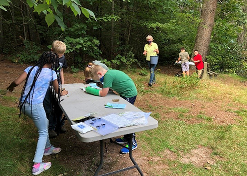 Fourth-graders examine pond invertebrates.