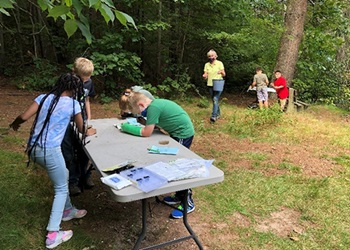Fourth-graders examine pond invertebrates.