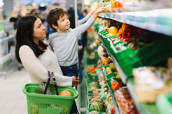 Young woman healthcare worker helping an older woman in a wheelchair in a park.