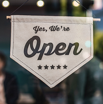 Sign on window saying: Yes, We're Open