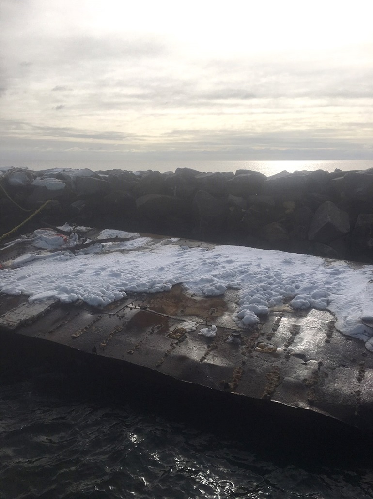 Large barge tied to the breakwater at Lighthouse Point Park, New Haven