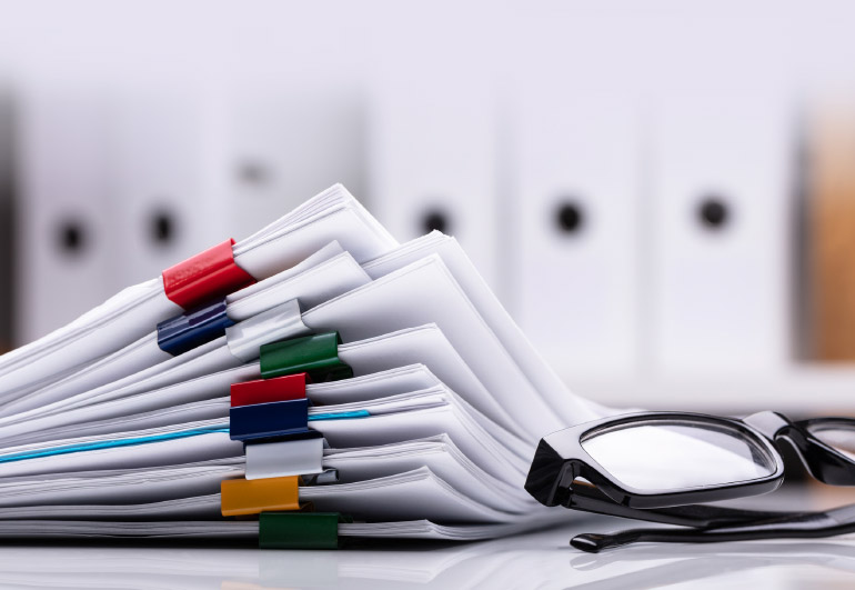 stack of paper with binder clips