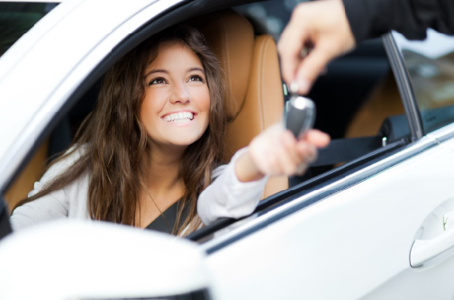 woman receiving new car keys