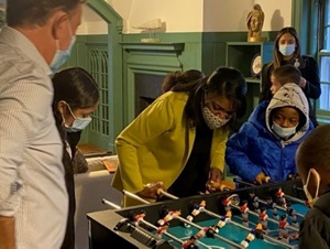 Commissioner Dorantes playing foosball with some children at the Governor's Mansion