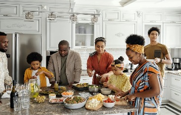 A gathering of people around a kitchen island. 
