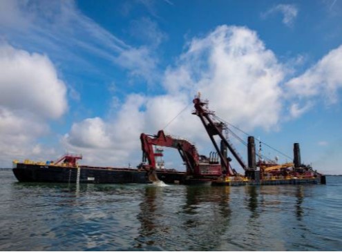 Dredge boat at sea on clear day. 