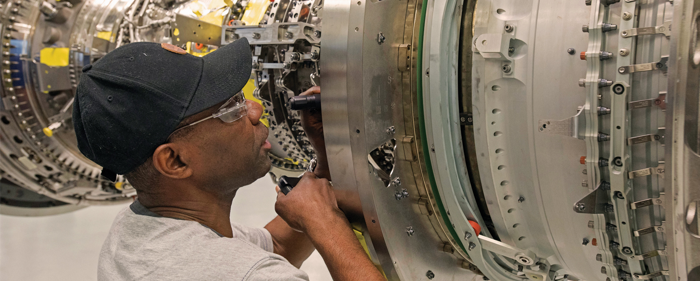 An engineer looking at a mechanical gear system