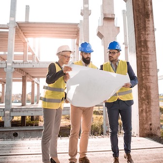 Three construction workers looking at a plan