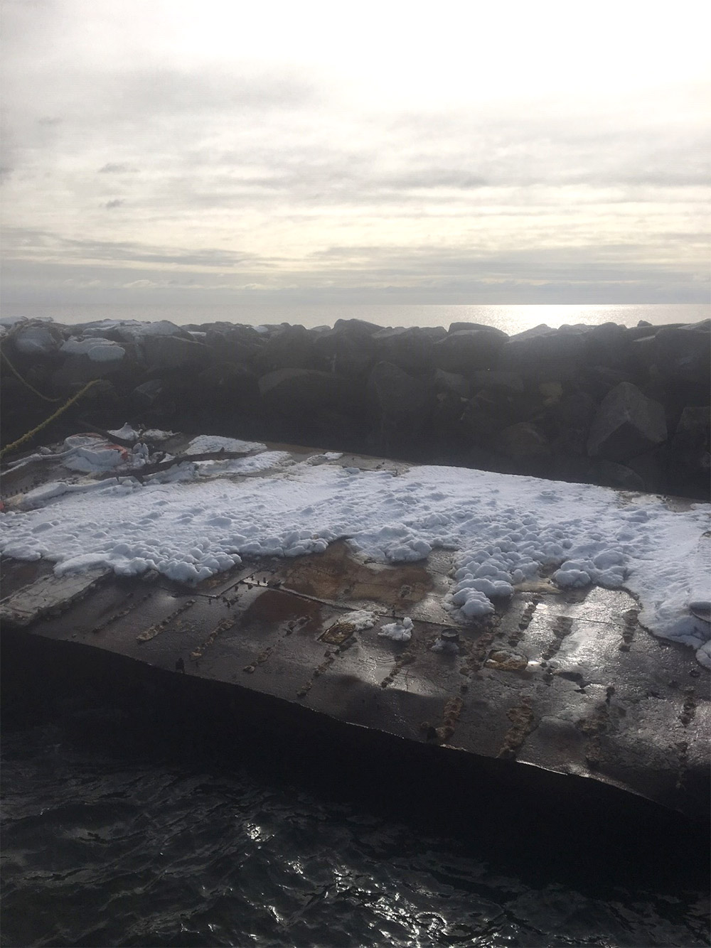 Large barge tied to the breakwater at Lighthouse Point Park, New Haven