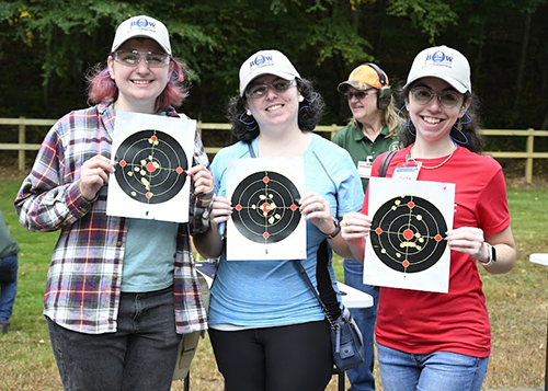 Three BOW Program participants hold up paper targets.