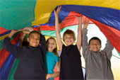 Kids holding fabric above their heads