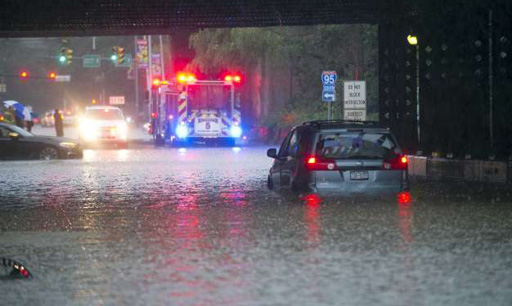 A van sits beneath the underpass after being abandoned due to rising flood waters on Elm St. in south Stamford, Conn. on Tuesday, Sept. 25, 2018.